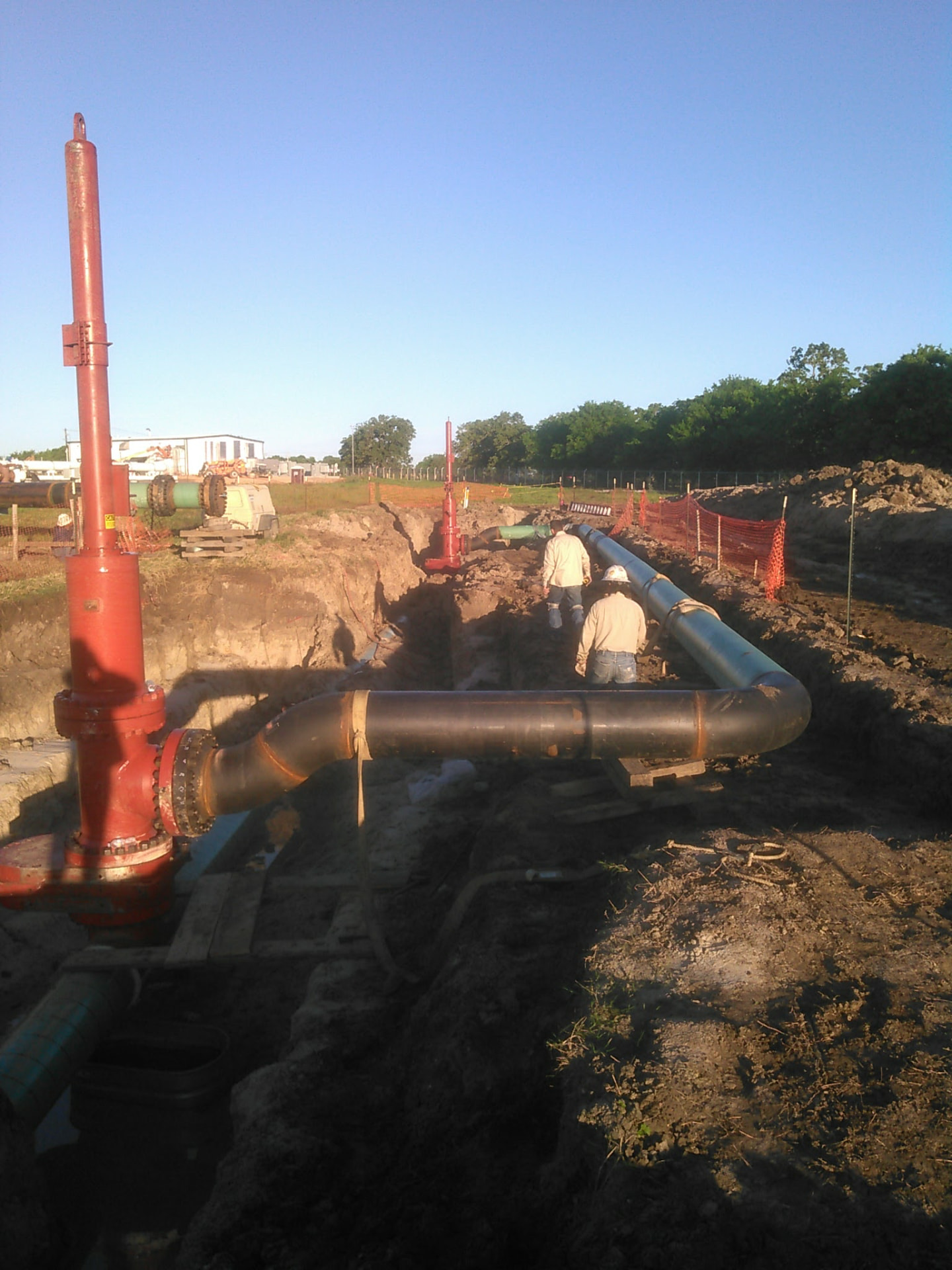 Pipeline tie-in with launcher risers being installed in an open trench