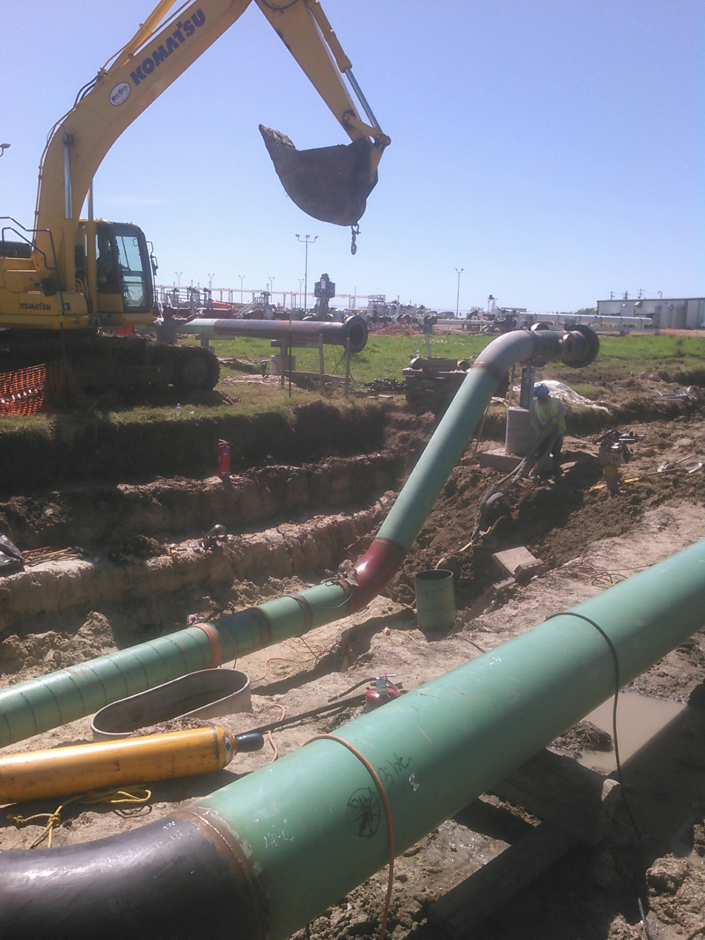 Coated pipeline sections being lowered in at a station tie-in